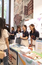 Three students talking with visitors